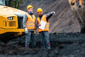Two men in hi-vis clothing stand in a quarry