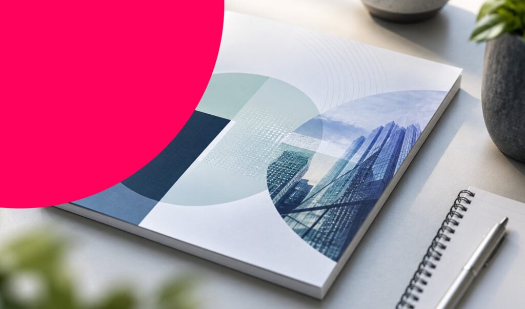 A printed booklet and a notebook with a pen on top are lying on a white table